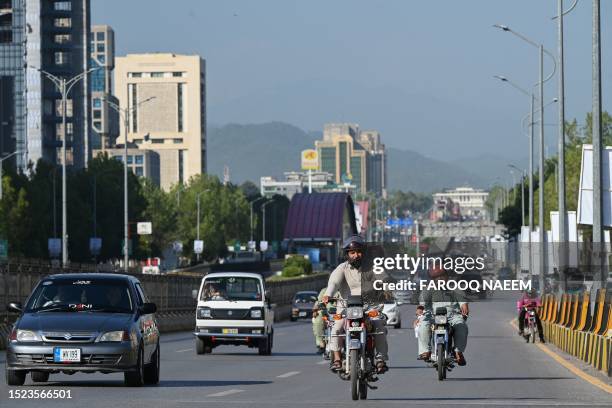 People commute on a road in Islamabad on July 11, 2023. Pakistan's desperately low foreign exchange reserves were boosted on July 11 with a $2...