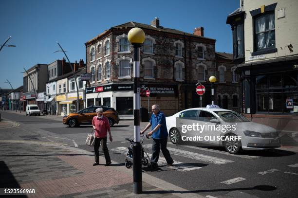 Members of the public walk across a road in Grimsby town centre, whose economy has been historically linked to the fishing industry, in Grimsby,...