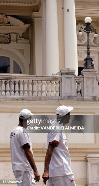 Two men look at the bullet holes left on the Guanabara palace, in Rio de Janeiro, Brazil 16 October 2002. Drug traffickers tried to take over a...