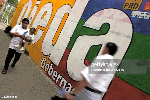 Pedestian walks by a mural supporting Revolutionary Democratic Party candidate for the Mexican state of Tabasco, Raul Ojeda, 04 August 2001 in...