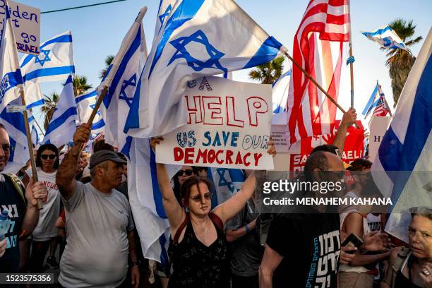 Demonstrators rally with Israeli and US flags during a protest against the Israeli government's judicial overhaul bill outside the US Embassy Tel...