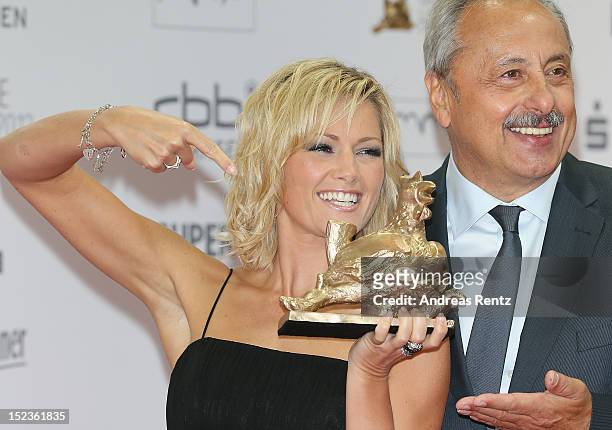 Helene Fischer holds up her award while Wolfgang Stumph smiles at 'Goldene Henne' 2012 award on September 19, 2012 in Berlin, Germany.