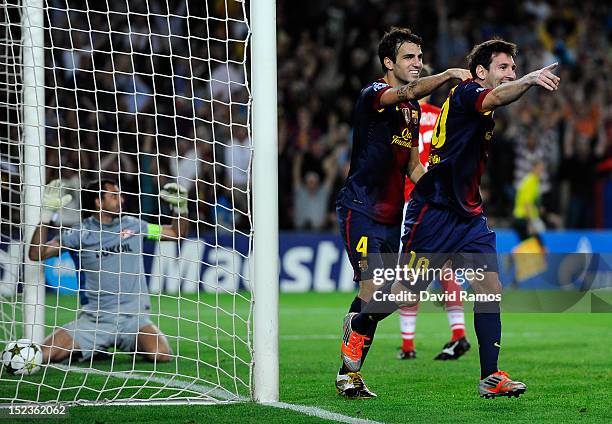 Lionel Messi of FC Barcelona celebrates with his teammate Cesc Fabregas after scoring his team's third goal during the UEFA Champions League Group G...