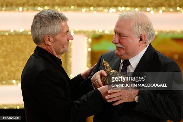 Former Polish President and Nobel Peace Prize winner Lech Walesa receives his award from Federal Commissioner for the Records of the State Security...
