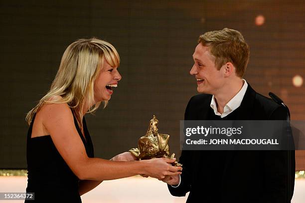 German actor Matthias Schweighoefer receives his award during the Golden Hen media prize awards ceremony on September 19, 2012 in Berlin. AFP PHOTO...