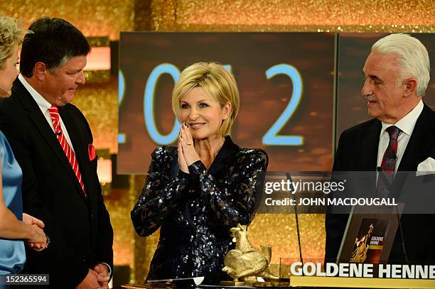 German TV host Carmen Nebel receives her award during the Golden Hen media prize awards ceremony on September 19, 2012 in Berlin. AFP PHOTO POOL /...