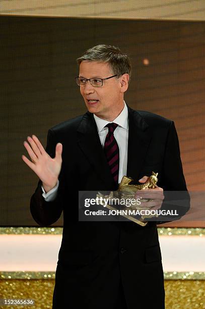 German TV host Guenther Jauch receives his award during the Golden Hen media prize awards ceremony on September 19, 2012 in Berlin. AFP PHOTO POOL /...