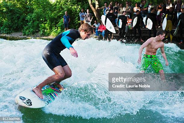 surfing on the eisbach, englischer garten - eisbach river stock pictures, royalty-free photos & images