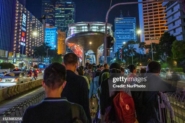People walks past in Jakarta business district during World Population Day in Jakarta on 11 July 2023. The United Nations marks World Population Day...