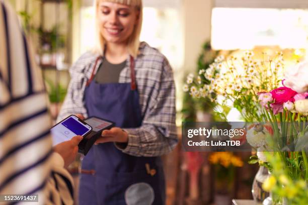 unrecognizable woman paying for a bouquet with her phone - app store stock pictures, royalty-free photos & images