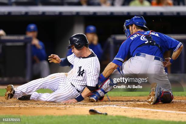 Jayson Nix of the New York Yankees is tagged out at home by J.P. Arencibia of the Toronto Blue Jays at Yankee Stadium on September 19, 2012 in New...