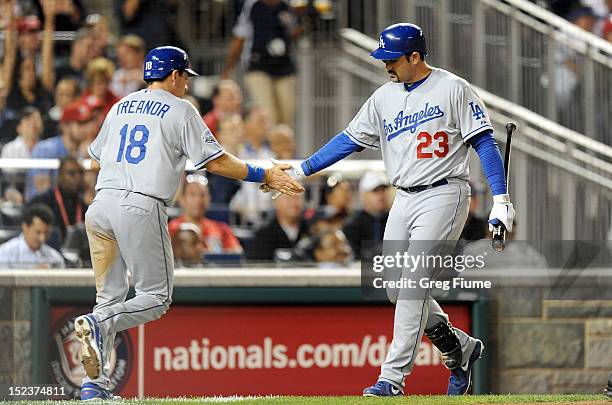 Matt Treanor of the Los Angeles Dodgers celebrates with Adrian Gonzalez after scoring in the fourth inning against the Washington Nationals at...