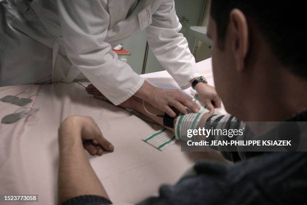 Un médecin psychiatre pose des électrodes sur le bras d'un patient, le 22 décembre 2006 à l'hôpital Saint-Jean de Dieu à Lyon. Sa création par...