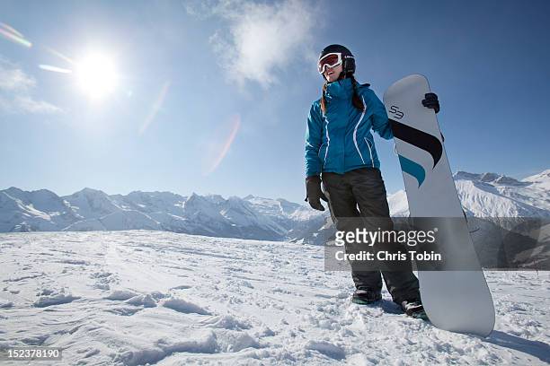 young woman standing on mountain with her snowboar - スポーツウェア ストックフォトと画像