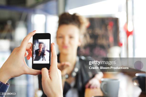 girl taking a photograph of her friend - fotografieren stock-fotos und bilder