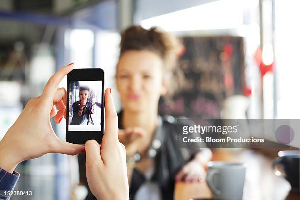 girl taking a photograph of her friend - photographing fotografías e imágenes de stock