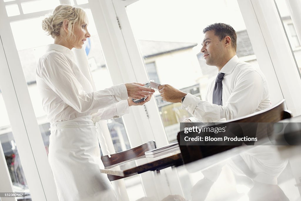 Business man paying in a restaruant