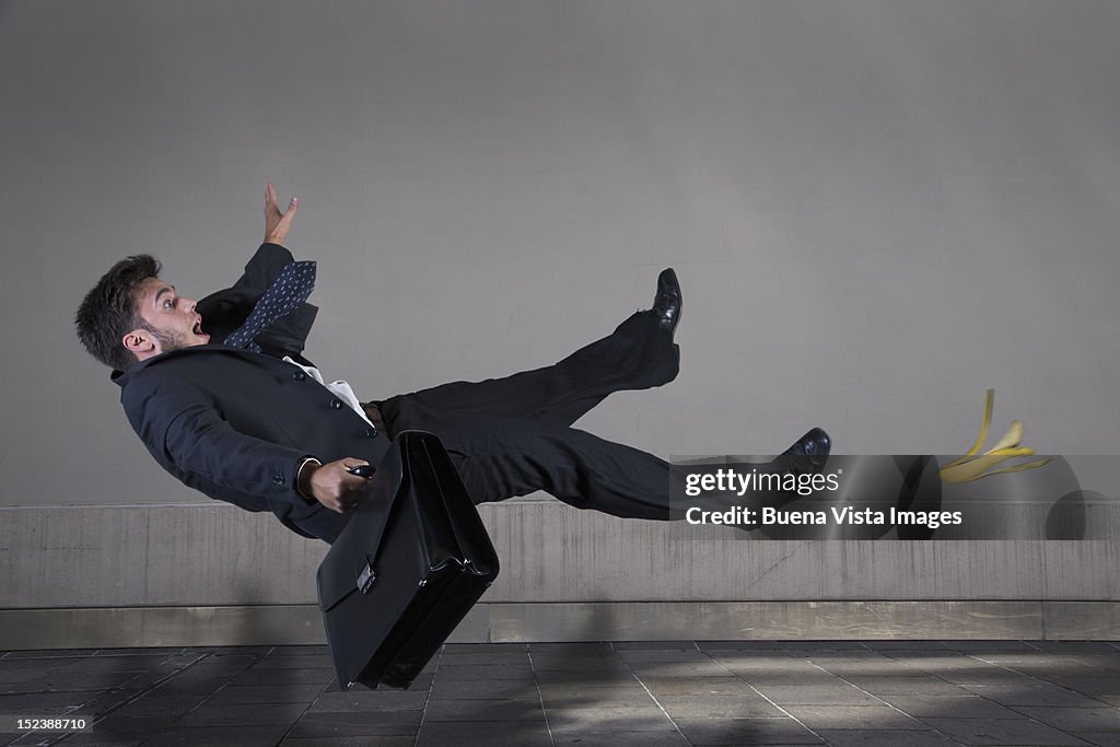 Businessman slipping on a banana peel