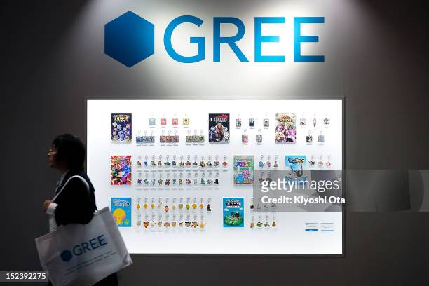 An attendee walks past a display of keyholders of characters from Gree Inc.'s mobile game titles at the company's booth during the Tokyo Game Show...