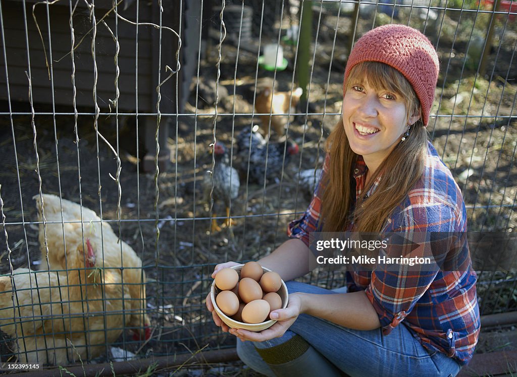 Young woman holding bowl of free range eggs