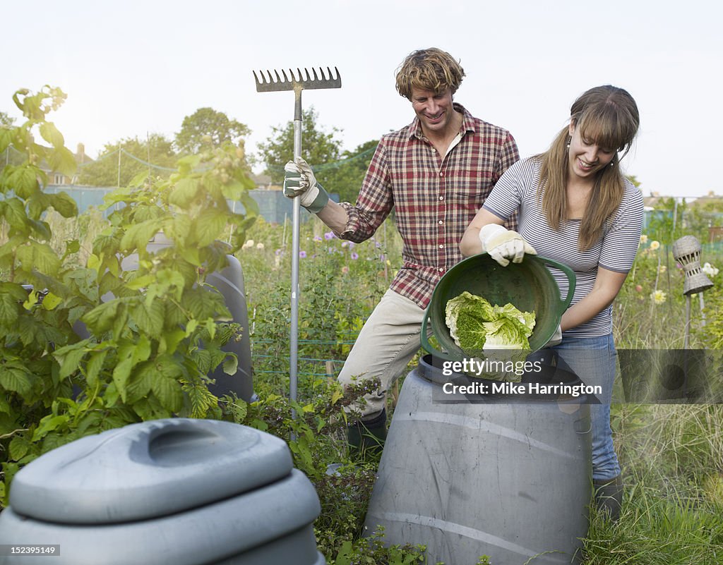 Couple depositing waste into compost bin