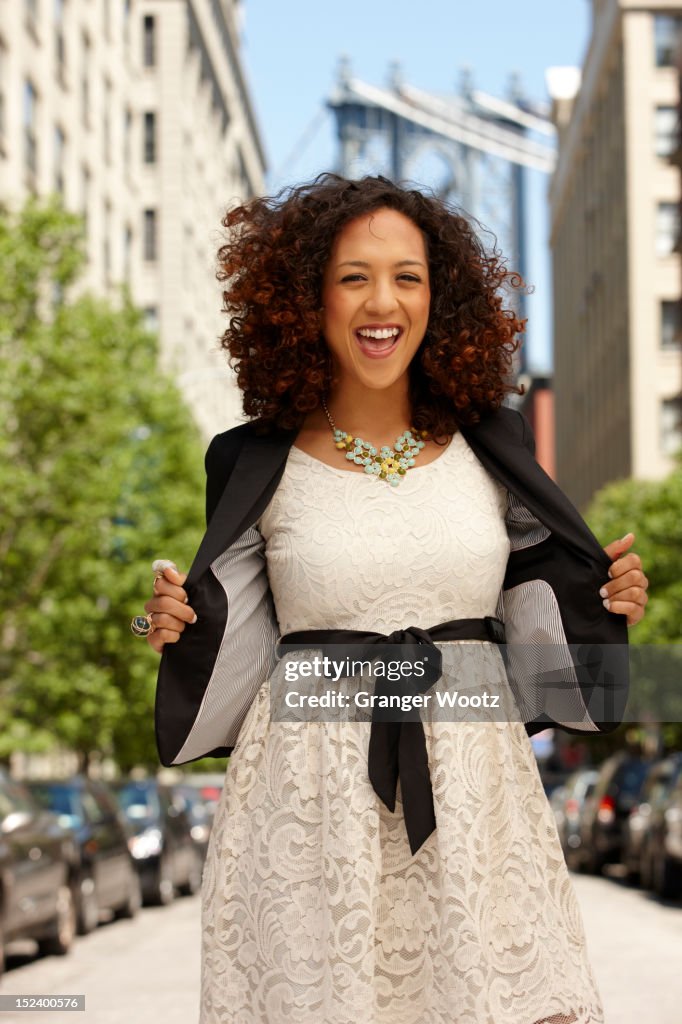 Grinning mixed race woman on urban street