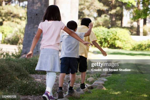 korean children balancing on stones in yard - yard line stock-fotos und bilder