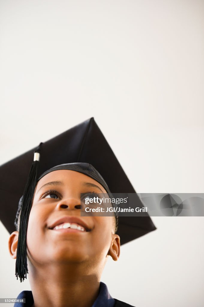 Smiling Black boy in graduation cap