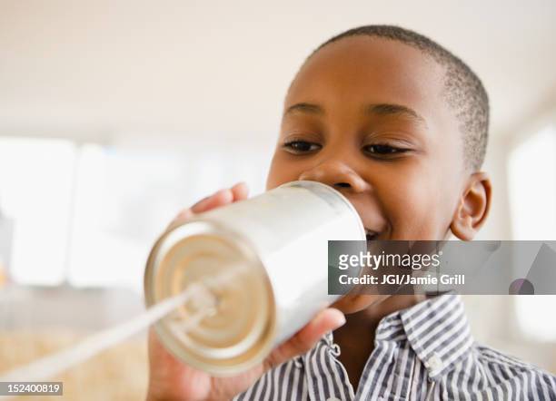 black boy talking into tin can phone - resourceful stock pictures, royalty-free photos & images