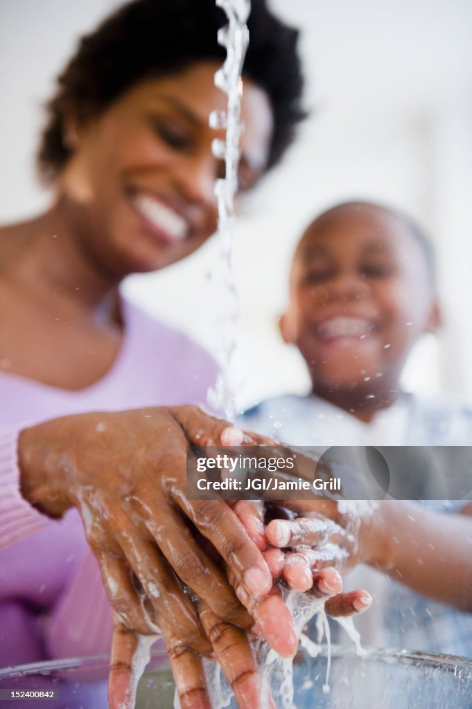 Black mother and son washing hands