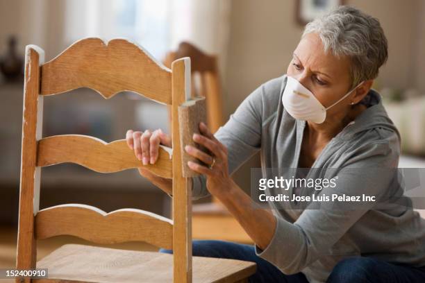 mixed race woman refinishing chair - restoring chair stock pictures, royalty-free photos & images