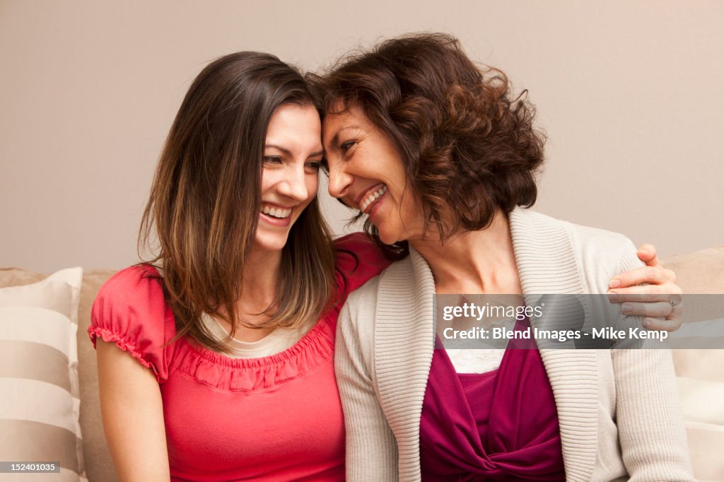 Caucasian mother and daughter sitting on sofa