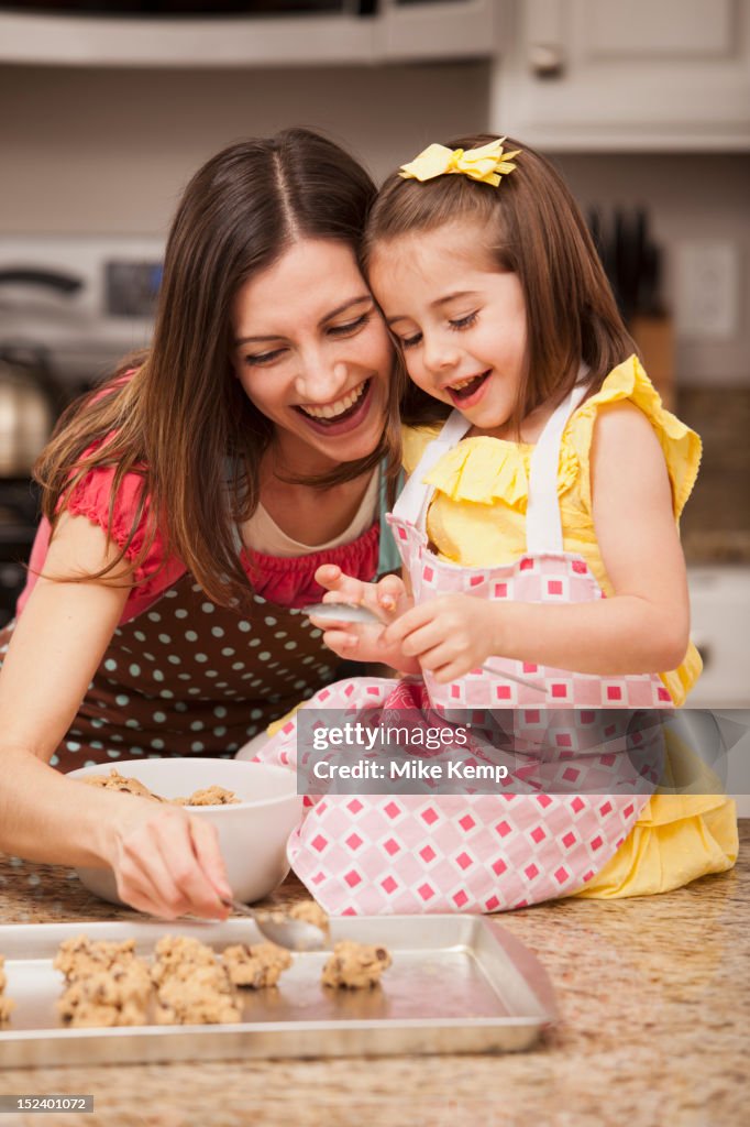 Caucasian mother and daughter baking cookies