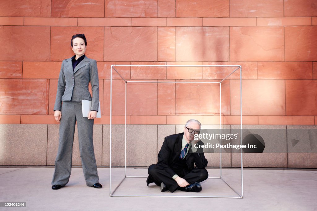 Businesswoman standing next to co-worker in box