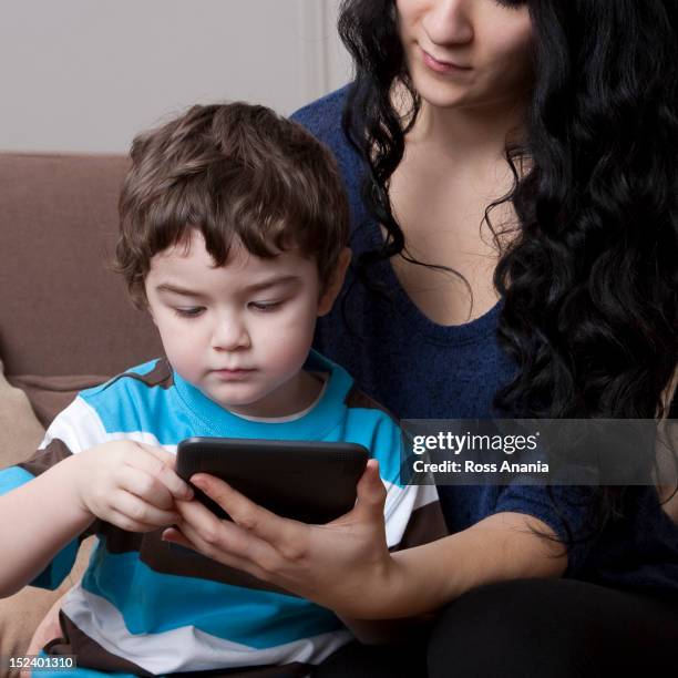 mixed race mother and son using digital tablet - online guidance stock pictures, royalty-free photos & images