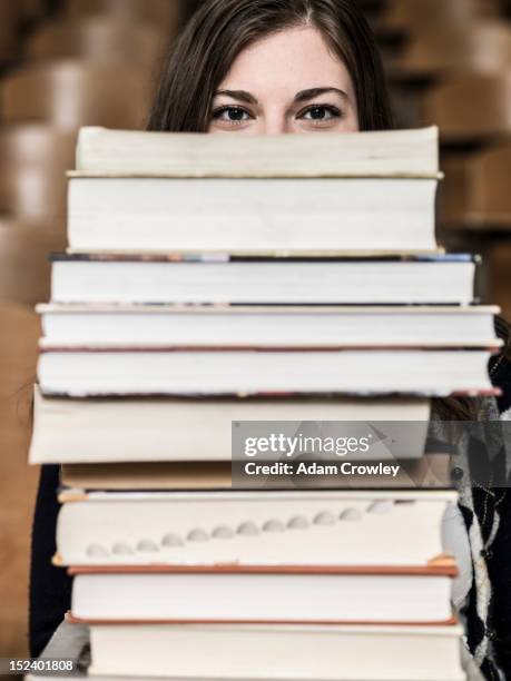 mixed race student holding stack of books - textbook fotografías e imágenes de stock