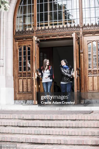 students coming out of college doorway - light coming through doors stock-fotos und bilder