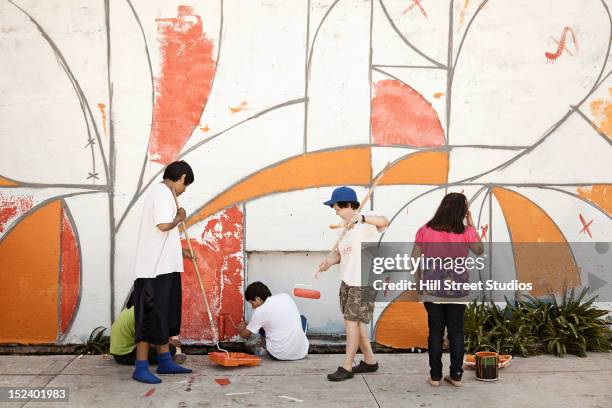 children painting wall together - indian painting stock pictures, royalty-free photos & images