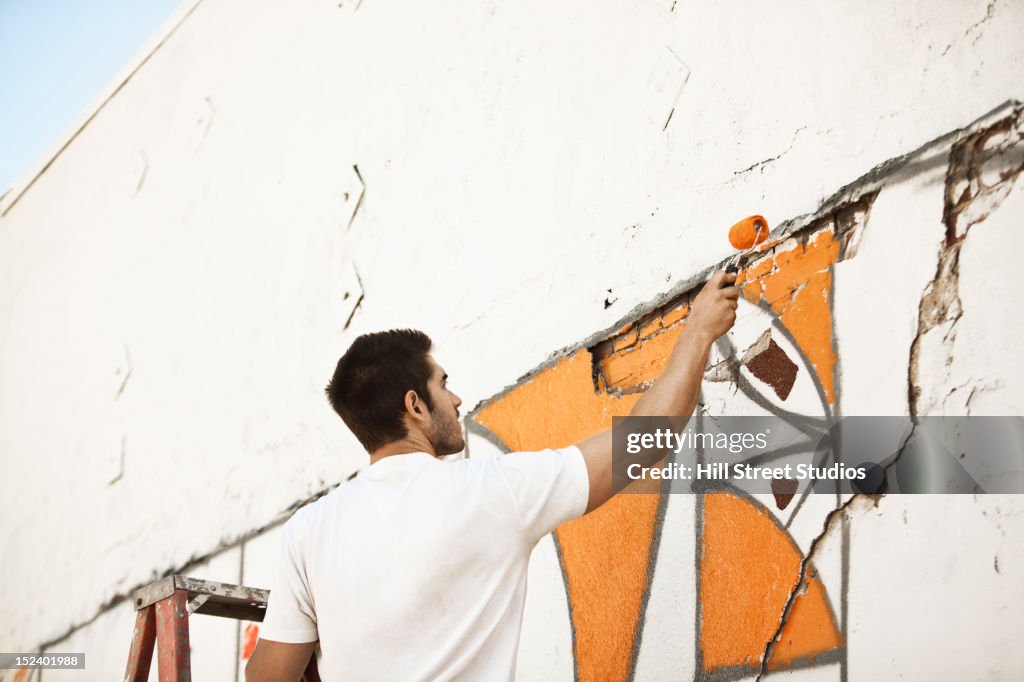 Caucasian man painting wall