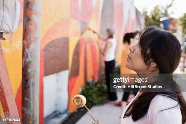 woman painting wall - peinture murale photos et images de collection