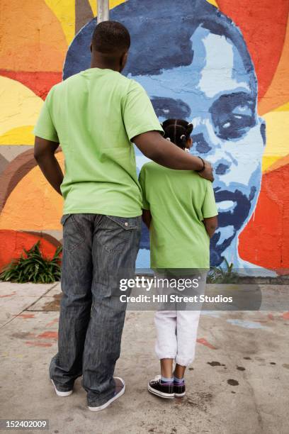 father and daughter looking at mural - father and children volunteering imagens e fotografias de stock