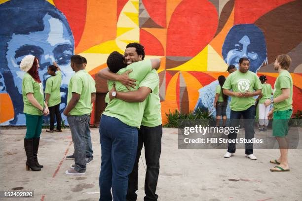 volunteers standing together - painted wall stockfoto's en -beelden