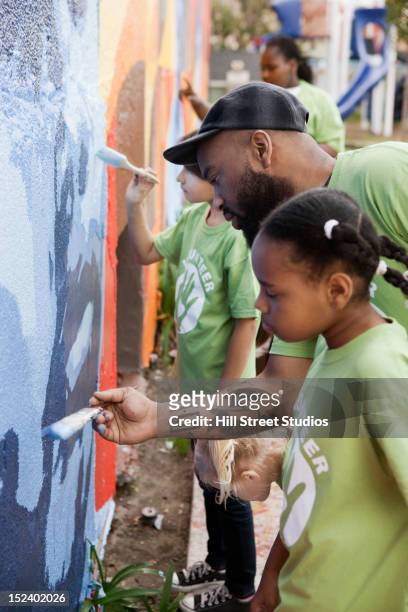 volunteers painting wall - wandmalerei stock-fotos und bilder