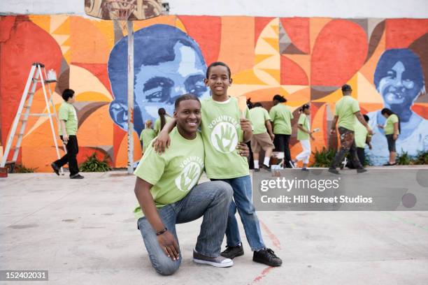 father and son volunteering - boy painting stock-fotos und bilder