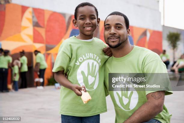 father and son volunteering - father and children volunteering stock-fotos und bilder