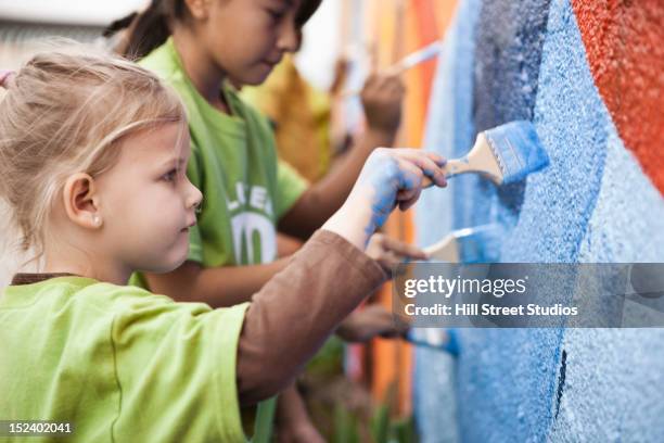 children painting wall - wandmalerei stock-fotos und bilder