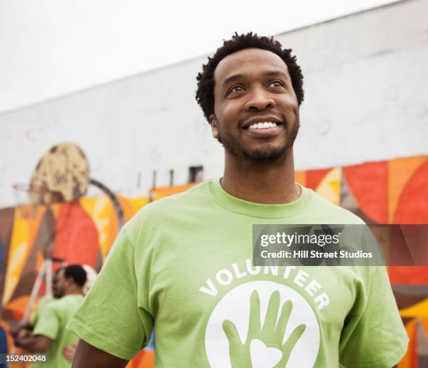 smiling african american volunteer - male volunteer stockfoto's en -beelden