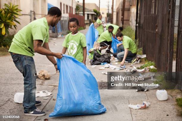 volunteers picking up litter in alley - environmental cleanup stock pictures, royalty-free photos & images