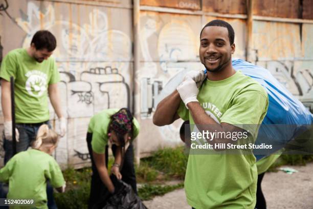 volunteers picking up litter - kids with cleaning rubber gloves stock-fotos und bilder