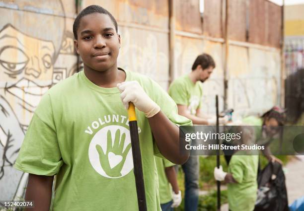 volunteers picking up litter - boy gift stockfoto's en -beelden